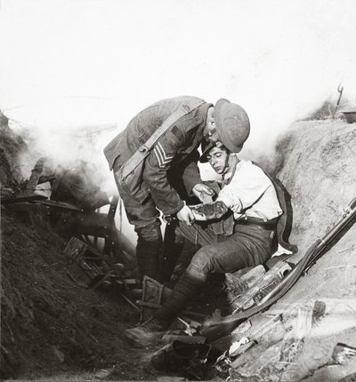 Receiving first aid from his sergeant in a sap during the height of battle at Peronne, 1918 by English Photographer